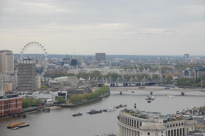 Blick aus einigen Dutzend Metern Höhe inmitten von London über den Fluss Themse. Am anderen Ufer ist das Riesenrad 'London Eye' sichtbar. Auf der Themse sind einige Schiffe.