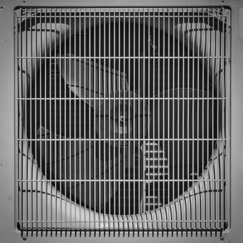 Ein grauer, detaillierter Ausschnitt eines Lüftungsgeräts mit Gittern.