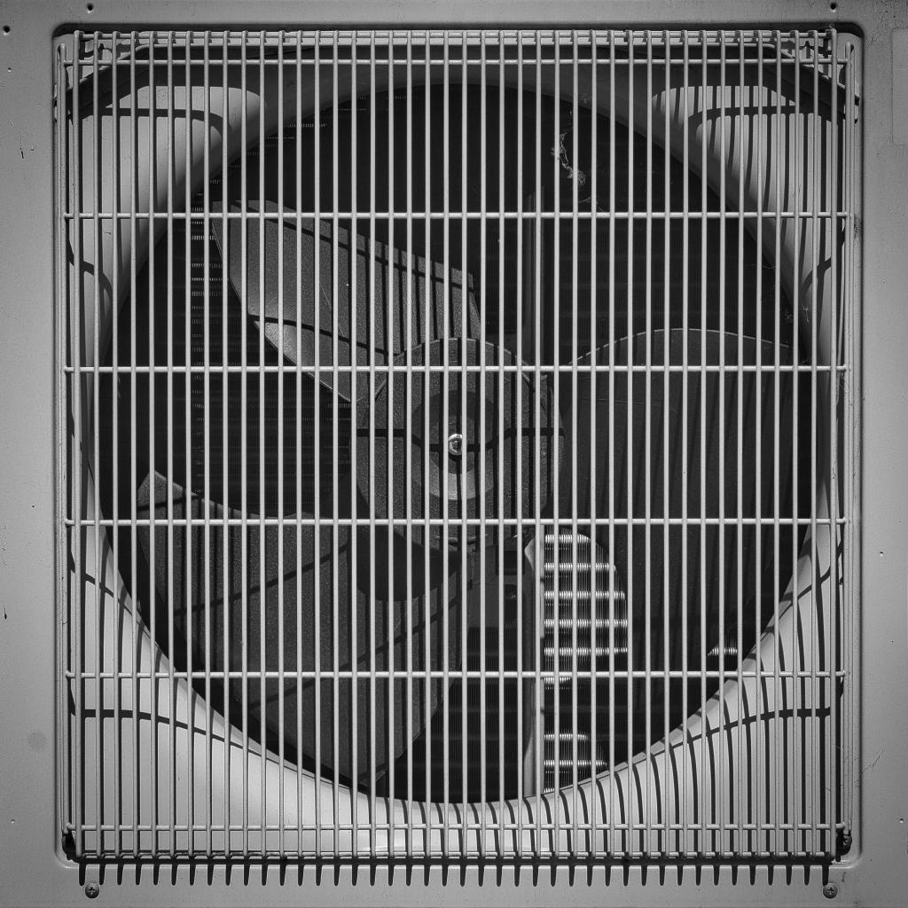 Ein grauer, detaillierter Ausschnitt eines Lüftungsgeräts mit Gittern.